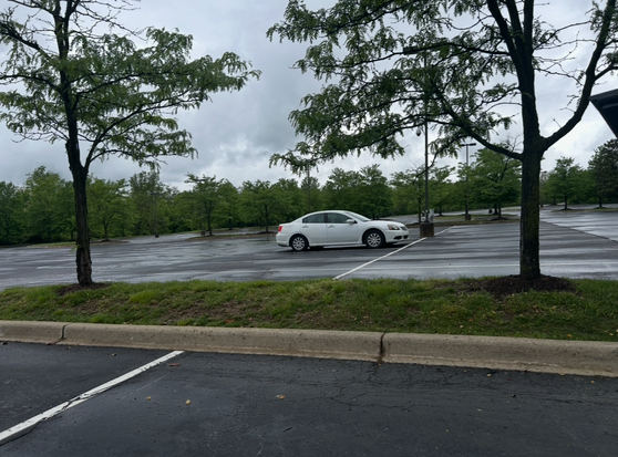 Image of a lone white car in a huge parking lot.