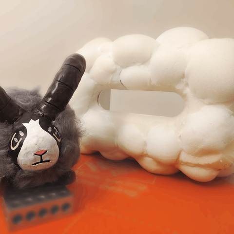 Dubwool's unattached head next to the tissue box body. The box has spheres of upholstery foam glued all over, not yet covered in wool.