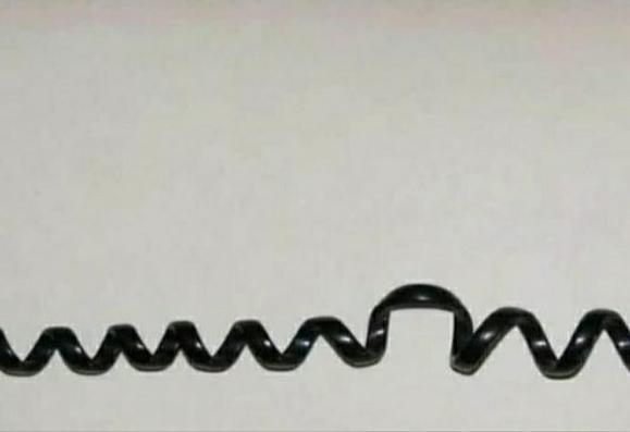 An old fashioned analogue line between the telephone and the handset. It's twisted regularly, except for one link