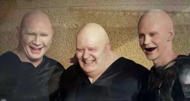 Picture of the three Harkonnen villains from Jacques Villeneuve's "Dune". From left to right: The Beast Raban, Baron Harkonnen, and Feyd-Rautha. They're bald, pasty white, dry-parched shiny, laughing evil laughs, and wearing all black.