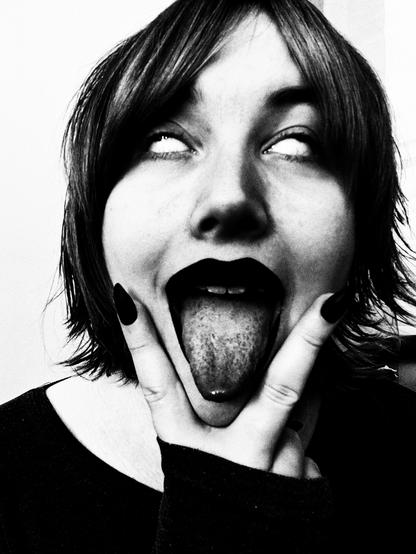Revy gritty b&w selfie 
She had two fingies posed beside her mouth and long tongue out
Her eyes rolling back to be white, like a demon