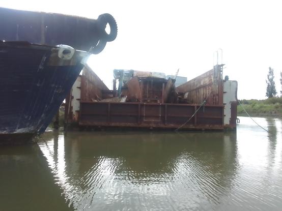 View from a rowing dinghy looking at the dry dock with its gate now welded shut for the passage to Erith, cut up remains of the 1921 'gentleman's motor yacht' to be seen over the gate
