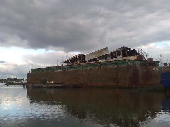 Another view of the dry dock with cut up parts of the motor yacht's superstructure loaded aboard for its final passage