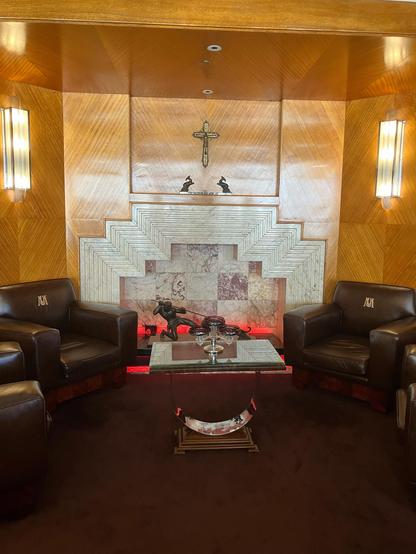 Two chairs and a coffee table in front of a fireplace, all art deco style
