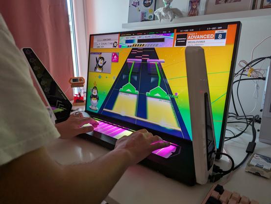 Tasoller plus controller on a desk with monitor attached to it playing chunithm