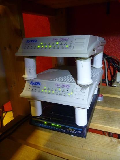Foto eines Turms aus ISDN-Modems: unten ein USR-Courrier-ISDN/V90-host, Darauf zwei Zyxel Elite 2864ID.