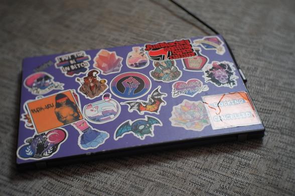 Mon laptop, il a une coque violette et il est recouvert de stickers dont la moitié parle de bisexualité
