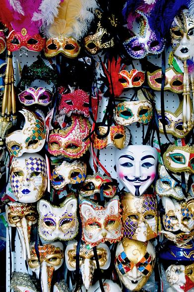 Bildbeschreibung im Kontext:
Ein dichtes, fast überladenes Sammelsurium an venezianischen Masken – prunkvoll, bunt, geheimnisvoll. Jede Maske scheint eine eigene Geschichte zu erzählen: Stolz, Verführung, Macht, Heiterkeit, Täuschung. Zwischen Glanz, Federn und Gold lugt die bekannte „Guy-Fawkes-Maske“ hervor – ein Symbol für Rebellion und verborgene Wahrheit. Doch all diese Masken haben eines gemeinsam: Sie verbergen. Sie tarnen. Sie spielen Rollen.

Im Kontext des Textes symbolisiert das Bild die Gesellschaft selbst:
Ein Karneval der Fassaden. Hinter jeder Maske könnte ein Mensch stehen, getrieben von Gier, gelähmt von Angst oder gefangen in Dummheit – gezwungen, das wahre Gesicht zu verbergen. Was bleibt, ist ein glänzender Schein, ein Theater der Selbsttäuschung.🖖