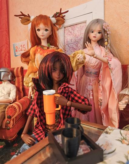 Cocoa Smart Doll with an orange Stanley Cup, two more Smart Dolls in the back