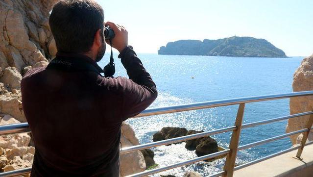 El biòleg Albert Burgas observant les Medes amb uns prismàtics (ACN/Xavier Pi)