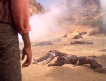 Jake standing before a field of dead bodies