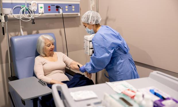 Enfermera preparando a una paciente con cáncer para su tratamiento. (Getty Images)