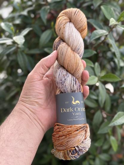 Écheveau de laine tenu dans une main. Provient du teinturier Italien Darkomen