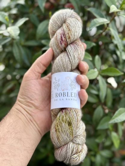 Écheveau de laine tenu dans une main. Provient de la teinturerie artisanale Espagnole El robersal de la santa