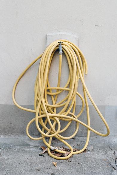 Un tuyau d'arrosage jaune rangé de façon très personnelle. Mais qui sommes nous pour porter un jugement ?