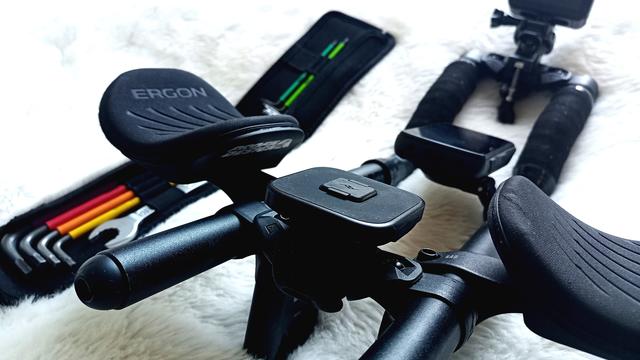 Eine Aerobar mit Armauflagen, Mobiltelefon-, Navigationsgerät- und GoPro-Halterung. Im Hintergrund ein Set Innensechskantschlüssel.