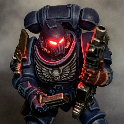 Space Marine 28mm miniature with glowing red LED eyes.