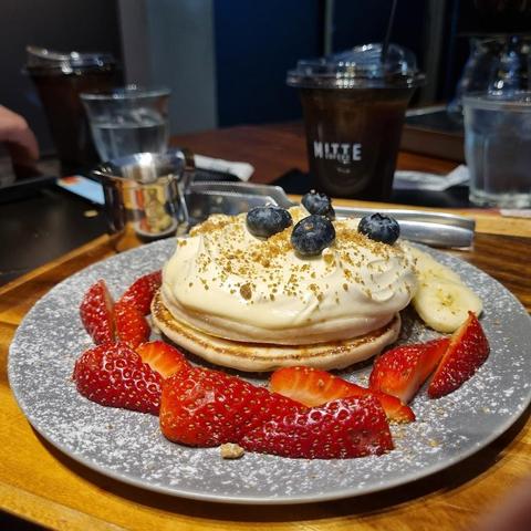 Pancakes with cream, blueberries, and strawberries.