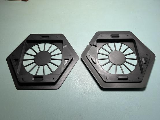 Two large hexagonal printed pieces.  One has four tapered, oddly shaped pegs on the mating surface, and the other has matching holes.
