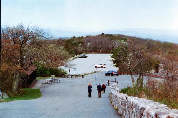 A view down a hill of a mountaintop parking lot