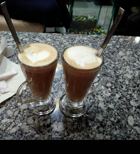 Two mugs of latte with latte art.