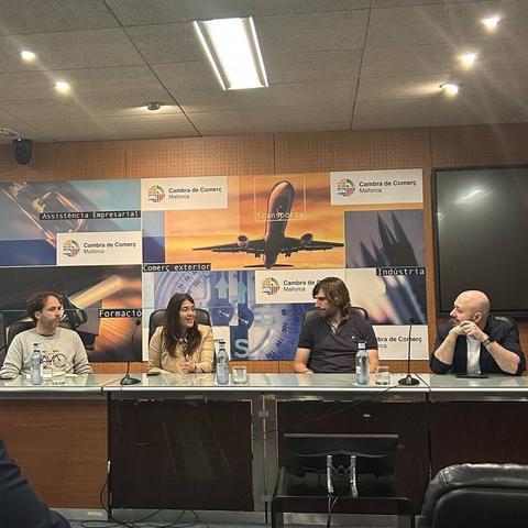 Un moment del Fòrum sobre Mobilitat Elèctrica en el turisme. A una taula, de cara al públic, hi ha quatre persones. A l'esquerra, el president d'Ecotxe, Alexandre Duran.