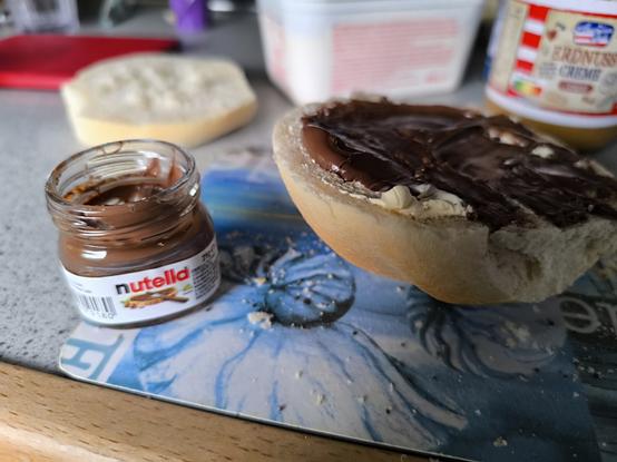 Brötchen, daneben ein winziges Nutella Probierglas