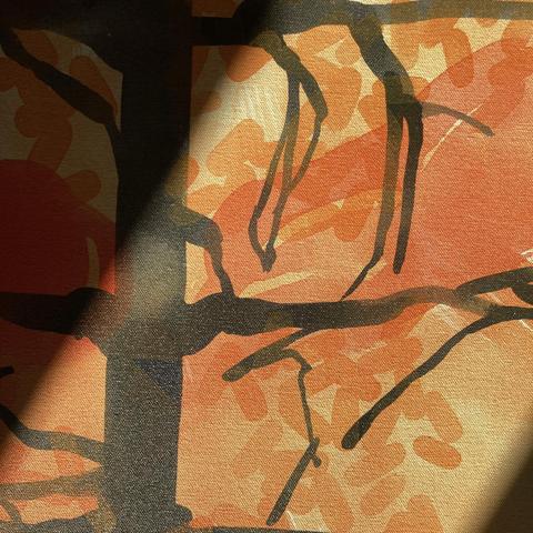 A close-up detail of an acrylic painting on canvas that is illuminated by a sunbeam. The detail is of an inky silhouette of a burnt tree trunk and branches against a pale orange background, gold-ish swarms of lozenge shapes, and a pale red blob.
