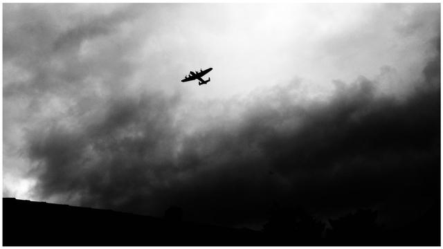 Crunchy black and white silhouette of a Lancaster bomber over Leighton Buzzard