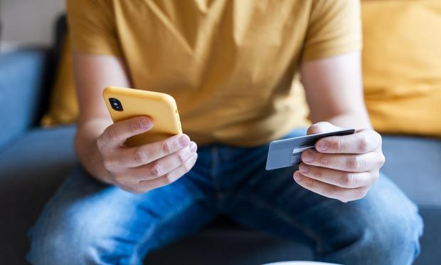 Una persona con un móvil y una tarjeta. (Getty Images)