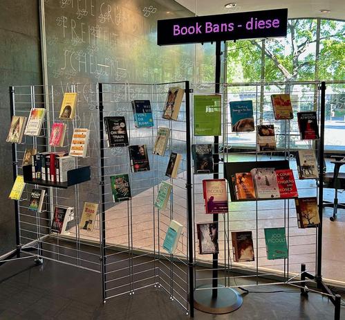Foto einer Medienpräsentation auf einem Regal mit verschiedenen Büchern, die in den USA zensiert werden