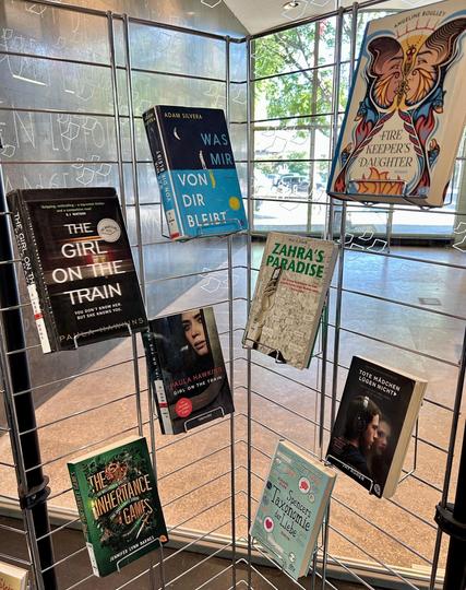 Foto einer Medienpräsentation auf einem Regal mit verschiedenen Büchern, die in den USA zensiert werden