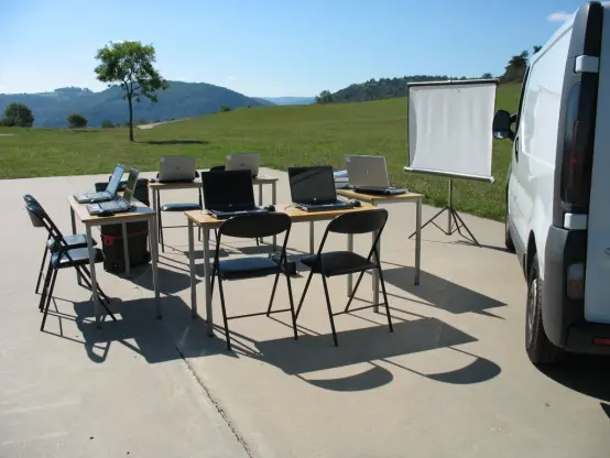 Tables et chaises et matériel informatique du CMI installés devant un paysage de collines de la Loire