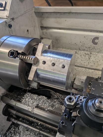 The 4" square blank getting turned on the lathe.  Grub screw holes to secure to the keyway were cut when the blank was still square.