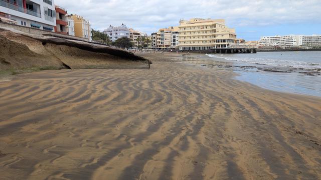 Una spiaggia con la sabbia che forma righe dall'aspetto diverso l'una dall'altra