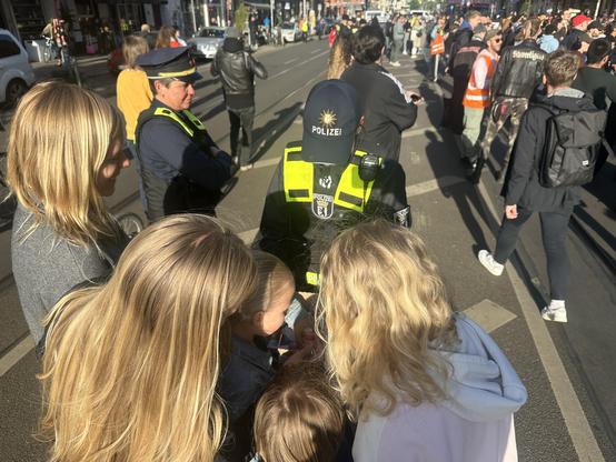 Polizistin verteilt Lollies an Kids und Infomaterial an Erwachsene.