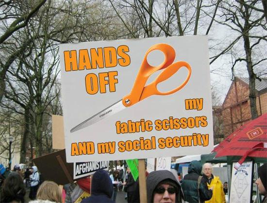 Large protest sign with a picture of Fiskars orange scissors on it and text "HANDS OFF my fabric scissors AND my social security"
