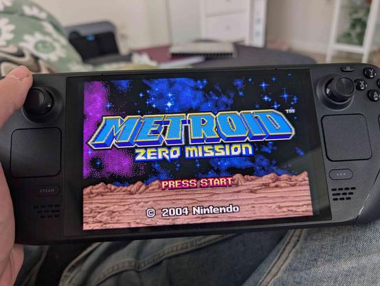 Me holding a Steam Deck displaying the title screen for "Metroid Zero Mission"