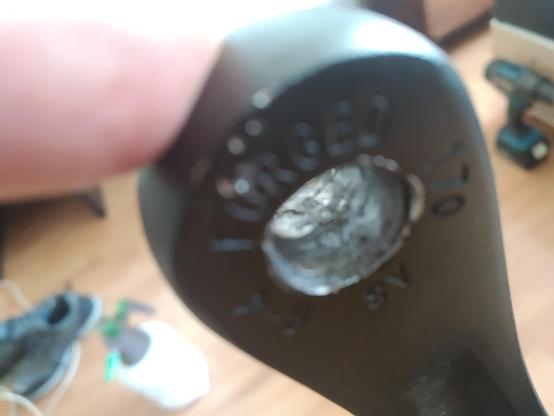 A bicycle crank with a bored out hole where the axle of the step used to be. The hole is grooved and pock marked aluminium on the inside