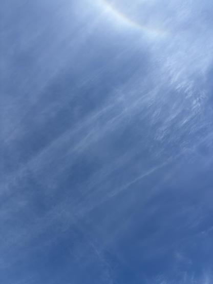 A clear blue sky with wispy clouds