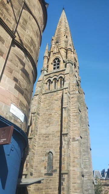 Tall, Gothic stone church tower, reaching up to a perfectly blue sky on a bright, spring morning