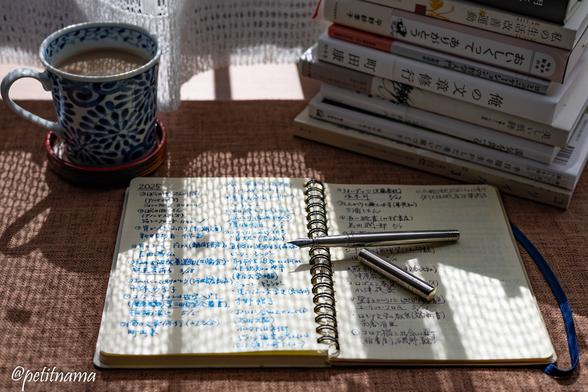 Coffee, reading notebook, recent books, fountain pen
