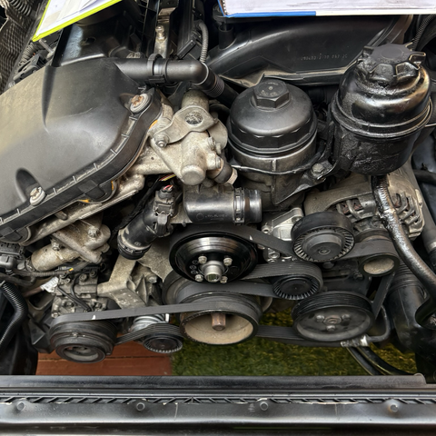The accessory drive belts installed in place on the front of the M54B30 engine in my 2003 BMW 530iT.