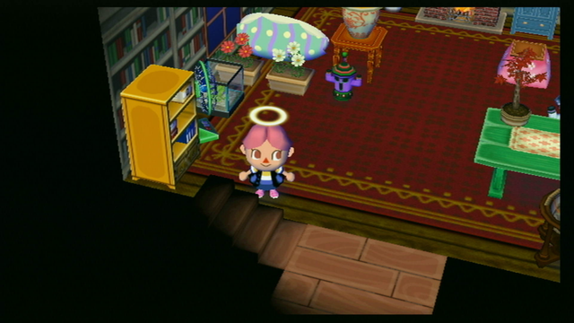One last view of the room showing the corner near the stairs. There is a fan and a bookshelf.