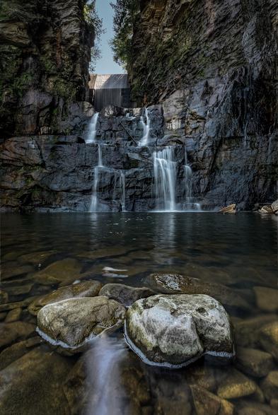 Several large rocks dominate the foreground in this close-up shot of the pool at the foot of High Falls, near Chateaugay New York, USA.