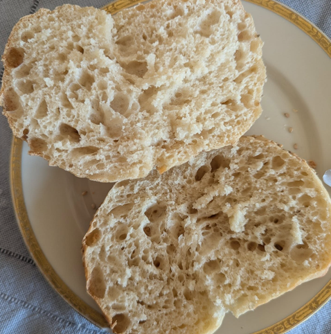 Zwei Brötchenhälften in Nahaufnahme auf einem weißen Teller mit goldenem, verziertem Rand