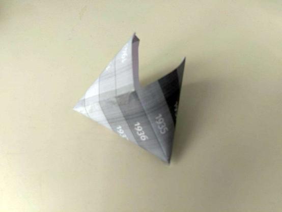 Ein Modell für eine dreidimensionale Tasche aus Papier. sog. Origamitasche. Eine Miniaturschwarzweißausdruck der im anderen Bild sichtbaren Bandes  wurde als Ausgangsmaterial verwendet.