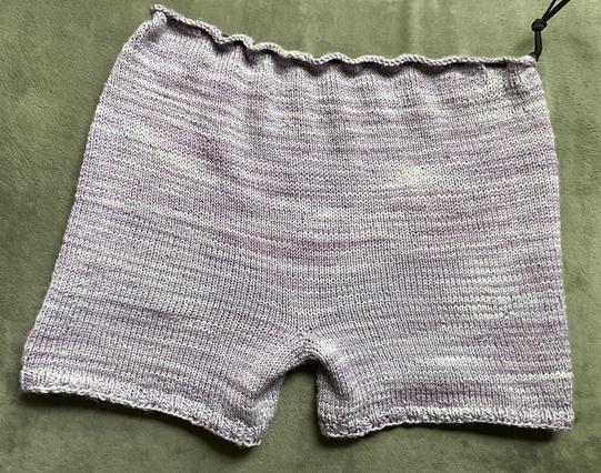 knitted purple shorts front view on grey cushion