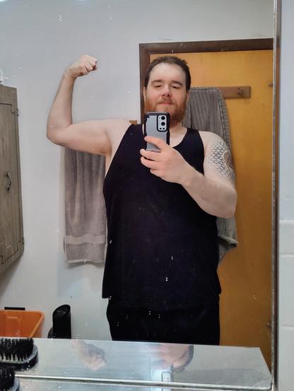 A photo of me flexing my left bicep in the mirror from April 2024