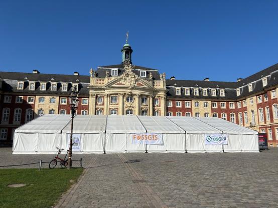 Photo of the conference venue, a tent with the University of Münster Castle in the background.
